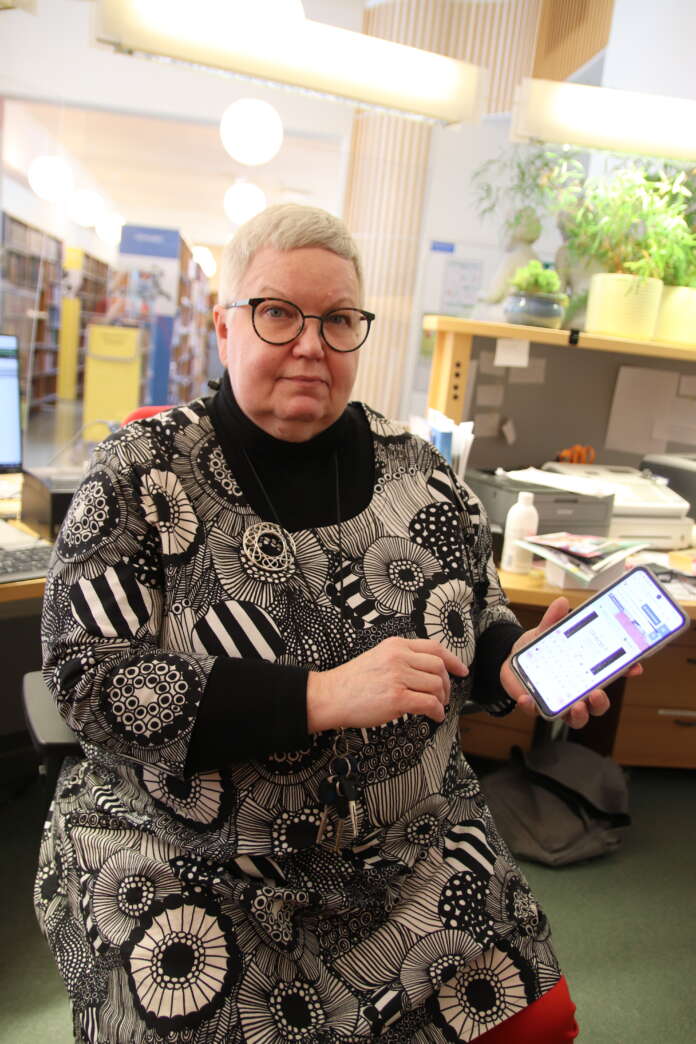 E-kirjasto-sovellus ladataan sovelluskaupasta omaan kännykkään, Sauvon kirjastonjohtaja Päivi Inkinen näyttää.